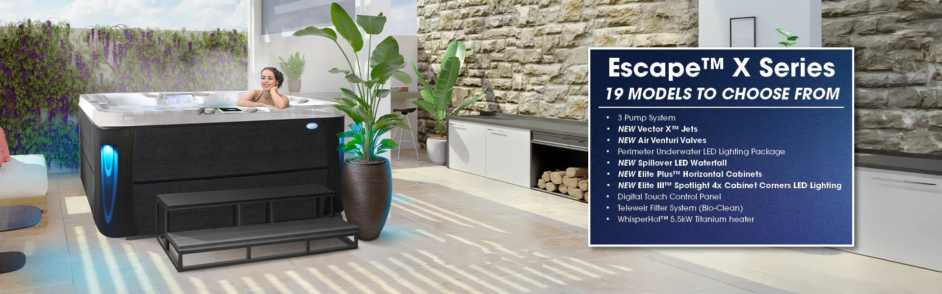 A person lounging in a Cal Spas Excape X hot tub with lime oak cabinet, blue lighted corners and 60-inch steps, in an outdoor living space.